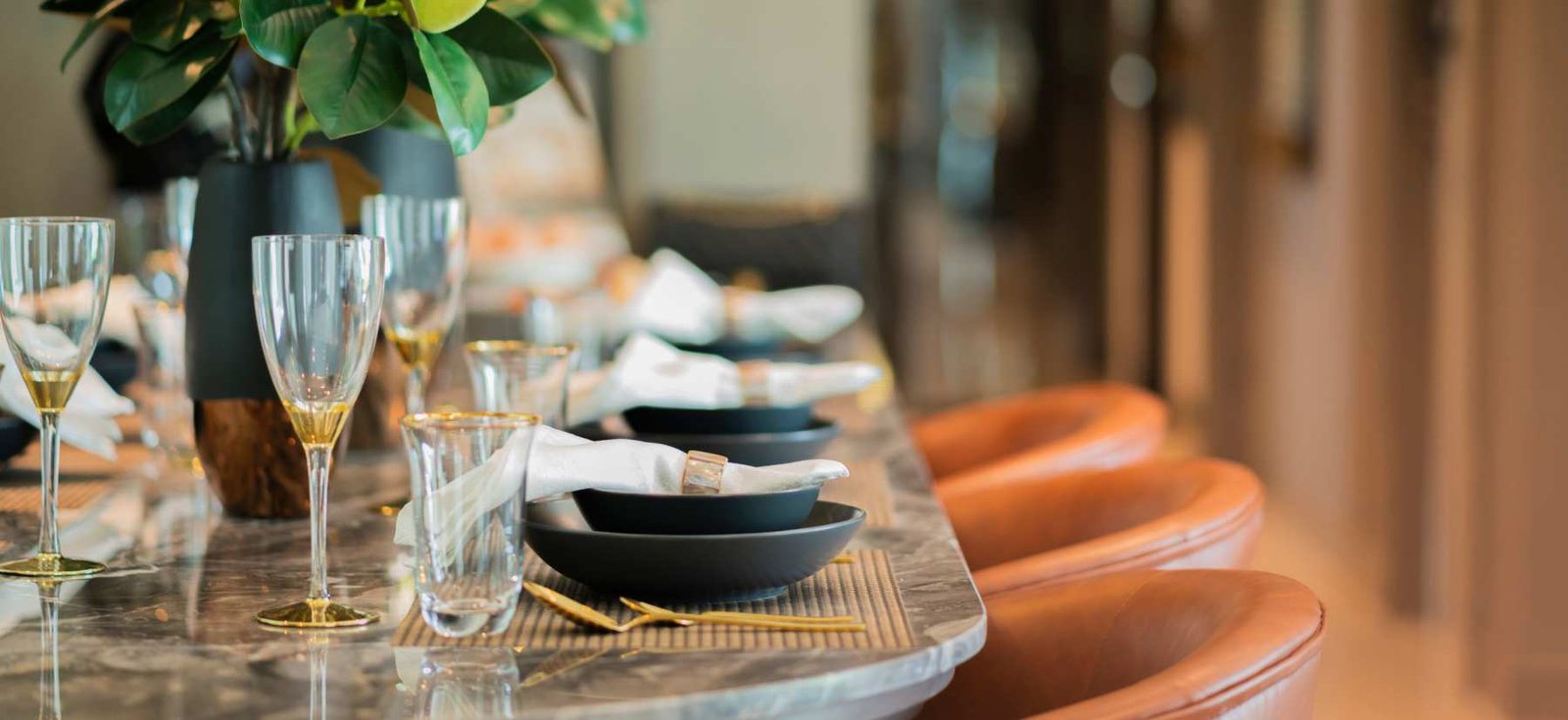 Elegantly set dining table with wine glasses and place settings