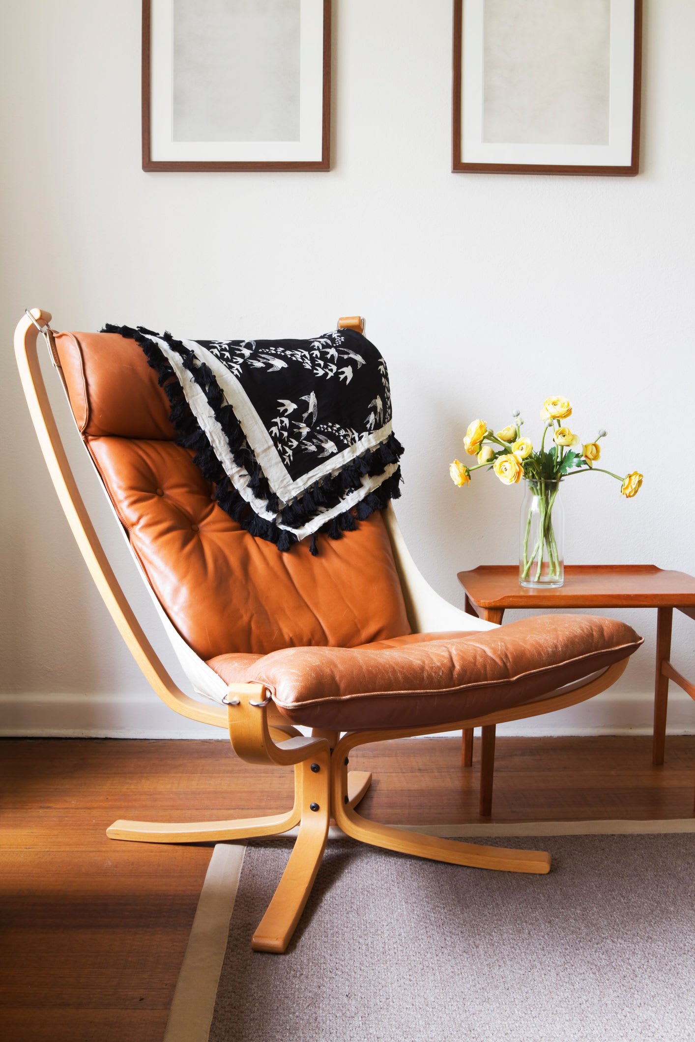 Cozy leather lounge chair with a throw blanket beside a window