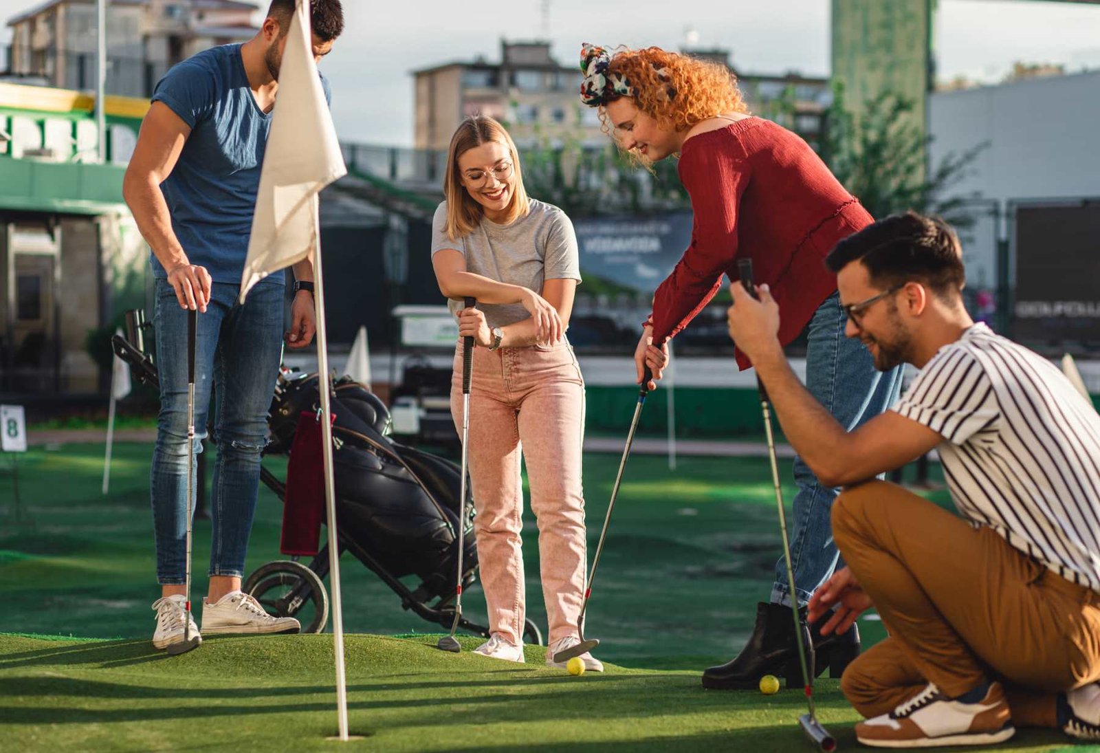 Friends playing mini golf together outdoors